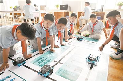 圖為中關(guān)村第三小學(xué)雄安校區(qū)編程社團(tuán)的學(xué)生檢驗(yàn)機(jī)器人的編程效果。新華社記者 李鑫攝